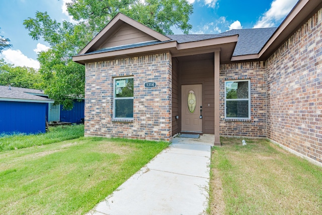 property entrance with a lawn