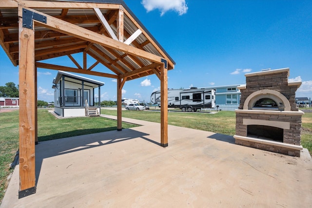 view of patio featuring a gazebo and an outdoor stone fireplace