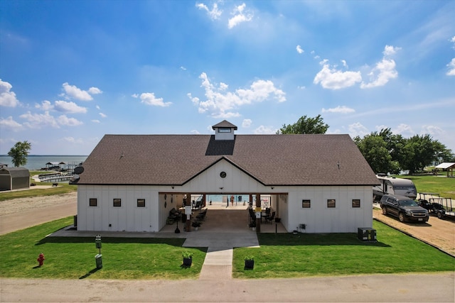 view of front facade featuring a water view and a front lawn