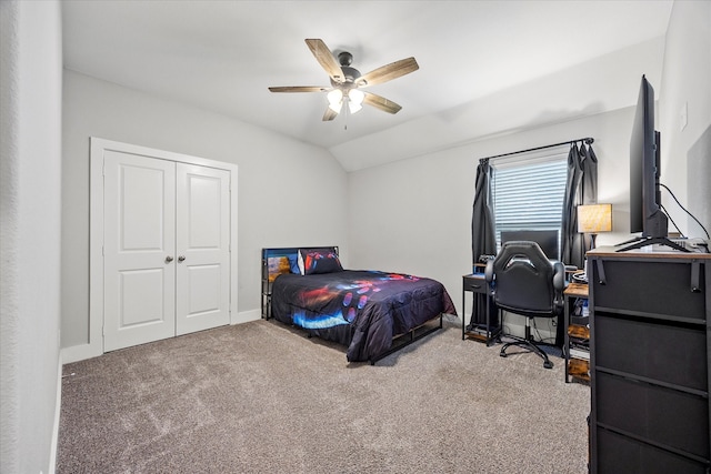 carpeted bedroom with ceiling fan, a closet, and vaulted ceiling