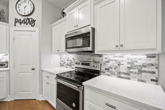 kitchen featuring decorative backsplash, white cabinetry, and appliances with stainless steel finishes