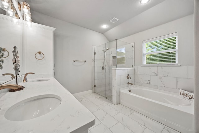 bathroom featuring vanity, independent shower and bath, and vaulted ceiling