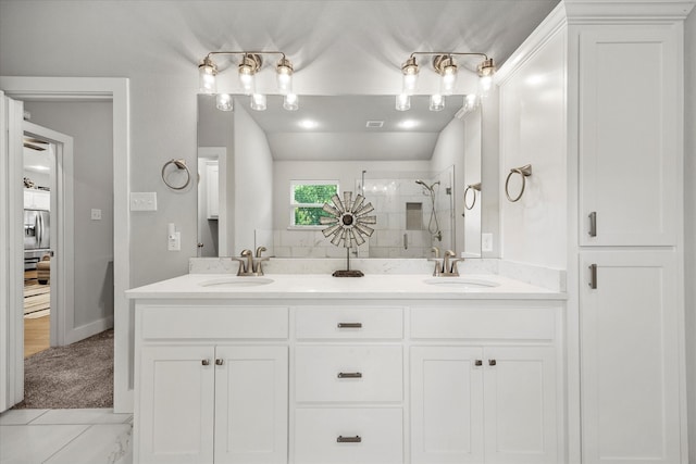 bathroom with a tile shower and vanity