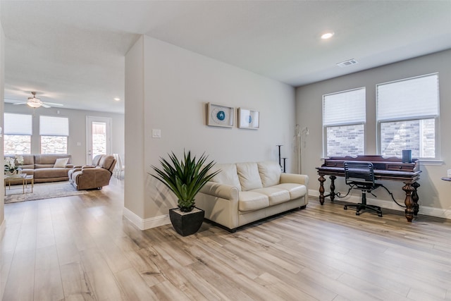 living room featuring ceiling fan and light hardwood / wood-style floors