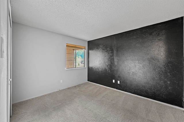 carpeted spare room with a textured ceiling