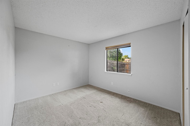 carpeted spare room with a textured ceiling