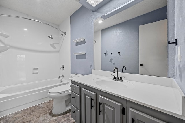 full bathroom with a skylight, vanity, a textured ceiling, shower / bathtub combination, and toilet