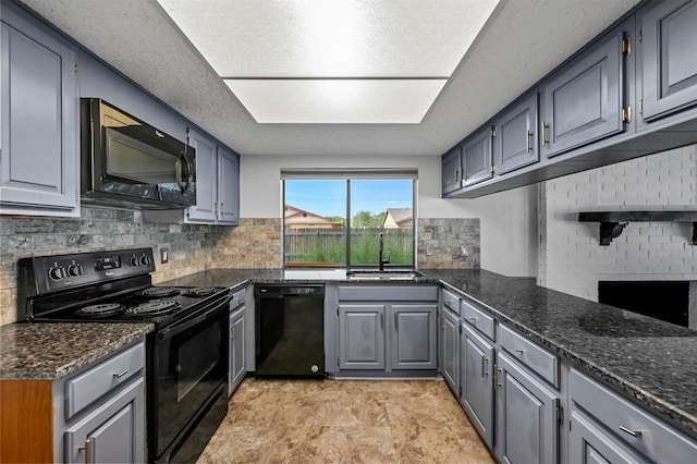 kitchen featuring sink, black appliances, gray cabinets, dark stone countertops, and decorative backsplash