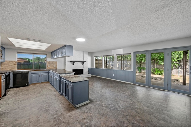 kitchen with dishwasher, kitchen peninsula, stainless steel range, and a textured ceiling