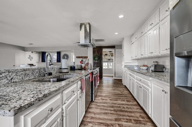 kitchen with white cabinetry, sink, light stone counters, extractor fan, and wood-type flooring