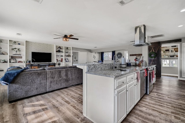 kitchen featuring light wood-type flooring, white cabinetry, sink, and exhaust hood