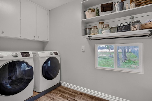 laundry room with washer and dryer, cabinets, and light wood-type flooring