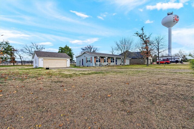 view of front of property featuring a garage, an outdoor structure, and a front yard