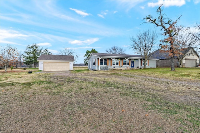 single story home with a porch, a garage, an outbuilding, and a front lawn