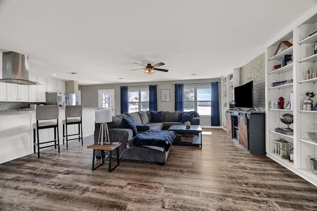 living room featuring ceiling fan and dark hardwood / wood-style flooring