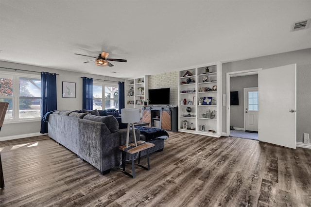 living room featuring dark hardwood / wood-style floors, ceiling fan, and built in features