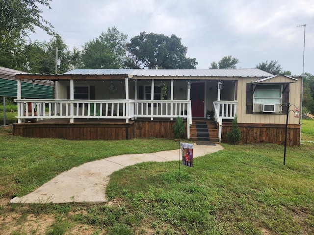 manufactured / mobile home with a porch, cooling unit, a front lawn, and metal roof