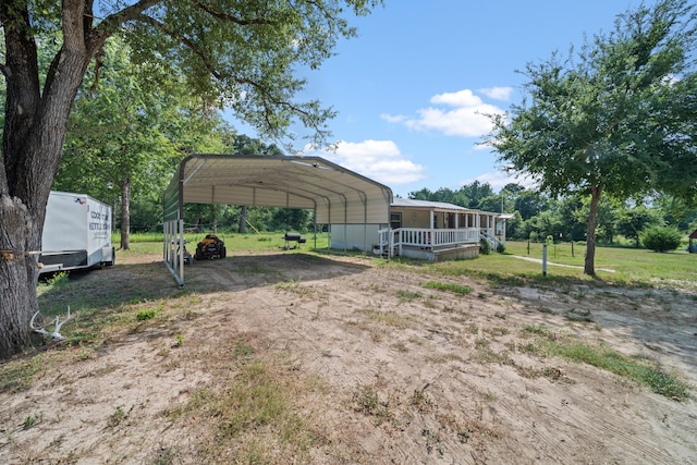 view of vehicle parking with a lawn and a carport