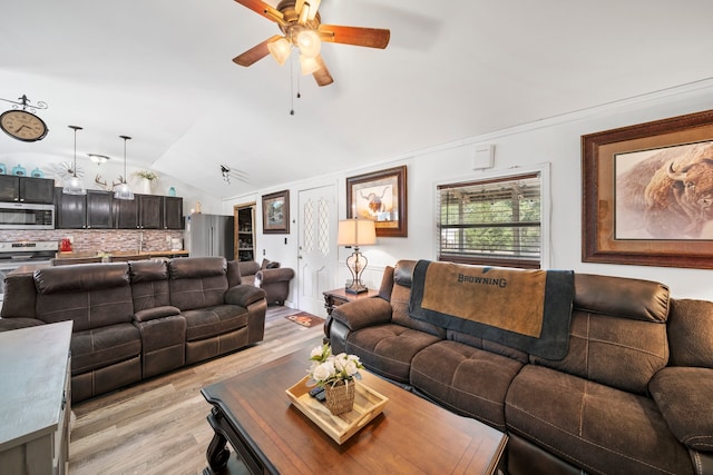 living room featuring lofted ceiling, light wood-style flooring, and a ceiling fan