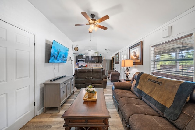 living room with light wood finished floors, a ceiling fan, and vaulted ceiling