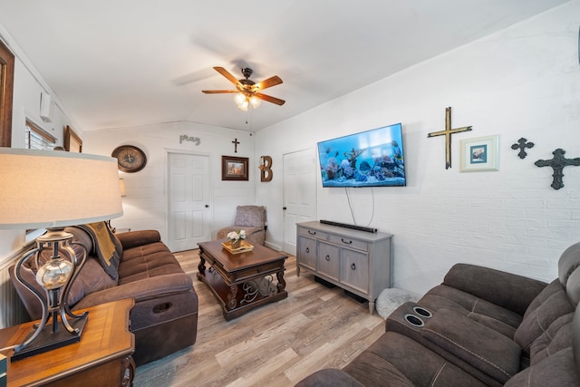 living room featuring ceiling fan, vaulted ceiling, and light hardwood / wood-style floors