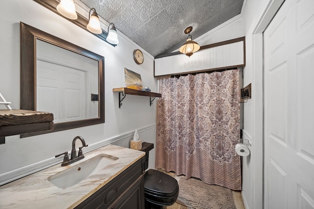 bathroom featuring a textured ceiling, lofted ceiling, crown molding, vanity, and toilet