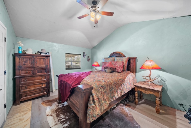 bedroom with light hardwood / wood-style floors, lofted ceiling, and ceiling fan