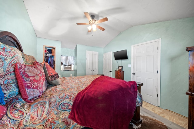 bedroom with cooling unit, lofted ceiling, two closets, and ceiling fan