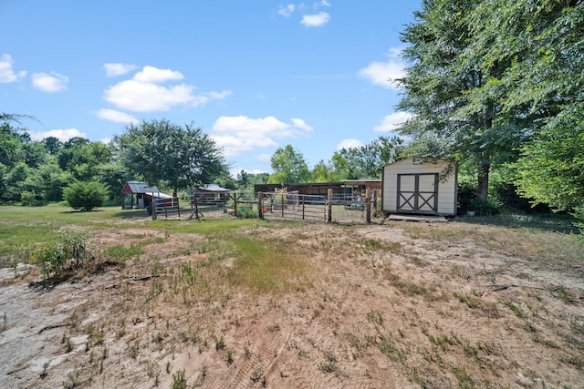 view of yard with an outbuilding, a storage unit, and fence