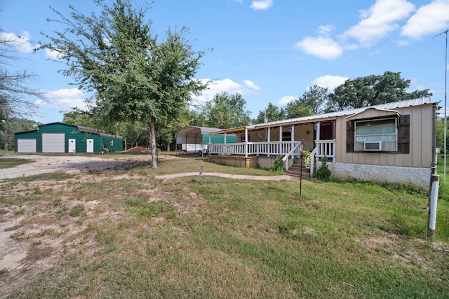 view of front facade with cooling unit, a porch, a front yard, and an outdoor structure