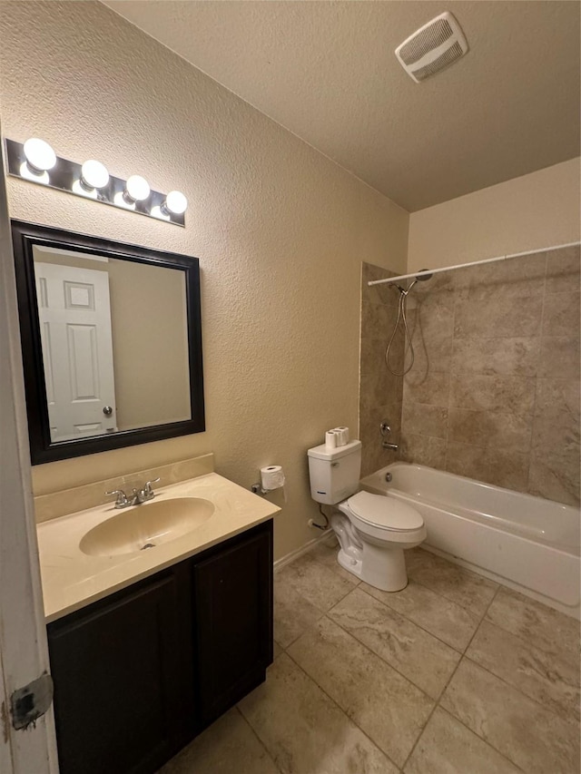 full bathroom featuring vanity, tiled shower / bath combo, toilet, and a textured ceiling