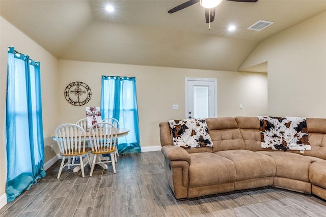 living room featuring hardwood / wood-style flooring, ceiling fan, and vaulted ceiling