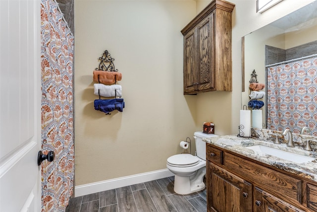 bathroom with walk in shower, vanity, and toilet