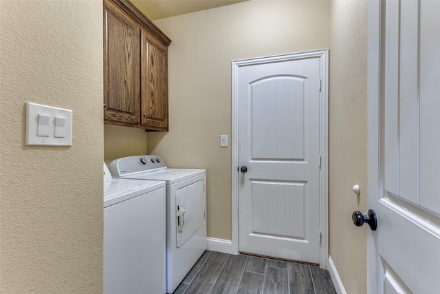 clothes washing area with cabinets and washer and clothes dryer