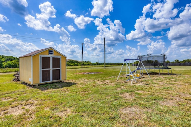 view of yard featuring a storage shed, a playground, and a trampoline