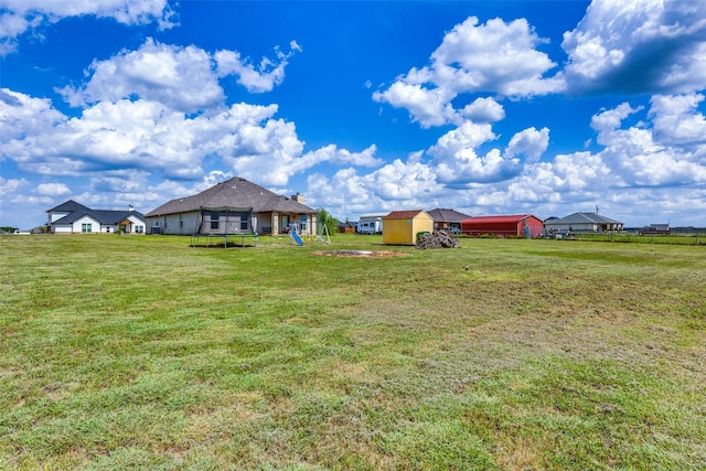 view of yard featuring a storage shed, a playground, and a trampoline