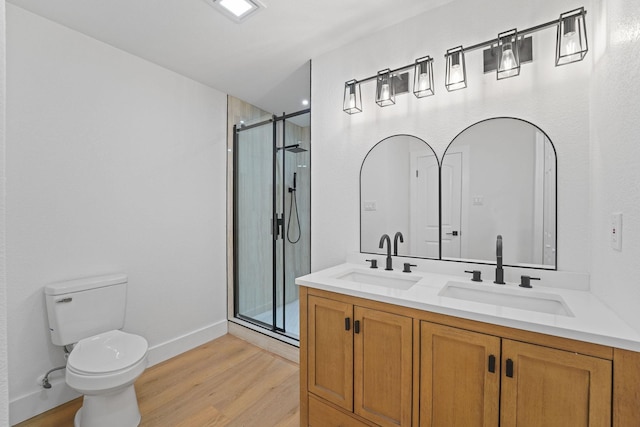 bathroom featuring toilet, wood-type flooring, walk in shower, and vanity