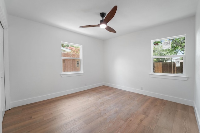 empty room with ceiling fan and light hardwood / wood-style floors