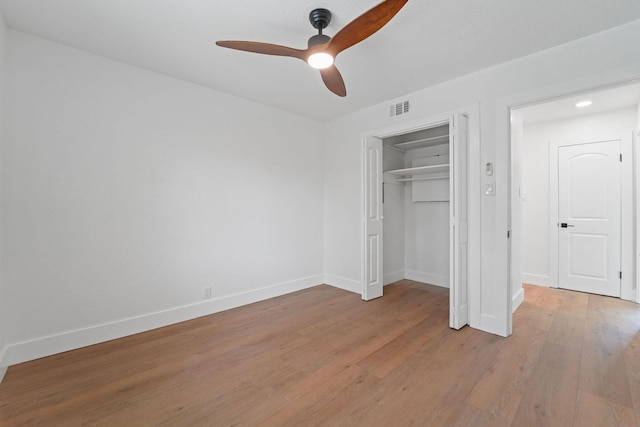 unfurnished bedroom featuring ceiling fan, a closet, and light hardwood / wood-style floors