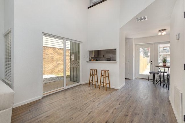 living room with french doors, hardwood / wood-style floors, and a high ceiling