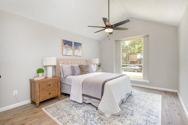 bedroom featuring ceiling fan, light wood-type flooring, and vaulted ceiling