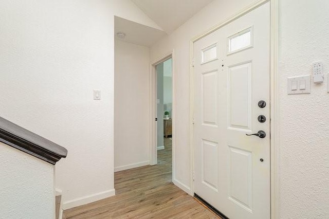 foyer with lofted ceiling and light hardwood / wood-style flooring