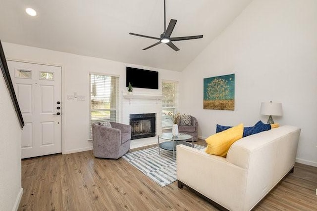 living room with hardwood / wood-style floors, high vaulted ceiling, and ceiling fan