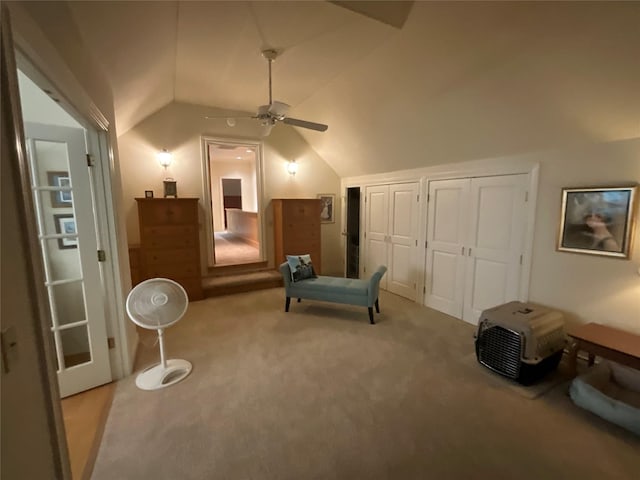 living area featuring carpet floors, ceiling fan, and lofted ceiling