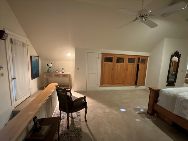 bedroom with ceiling fan, vaulted ceiling, and carpet flooring