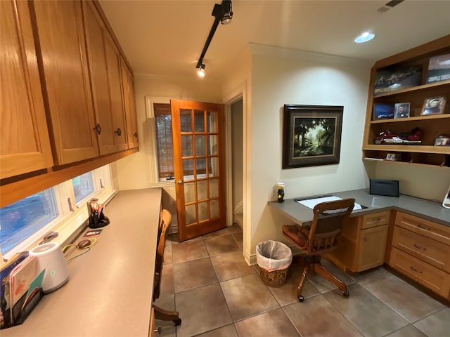 office area featuring built in desk, track lighting, and light tile floors