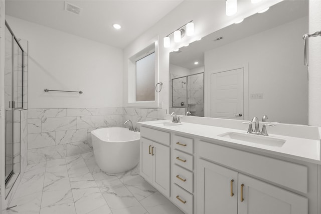 bathroom with vanity, tile walls, and shower with separate bathtub