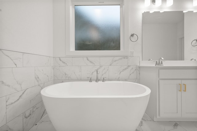 bathroom with vanity, plenty of natural light, a bath, and tile walls