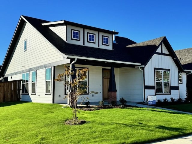 view of front of home with covered porch and a front lawn