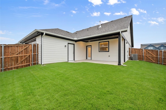 back of house featuring central AC unit, a patio area, and a lawn